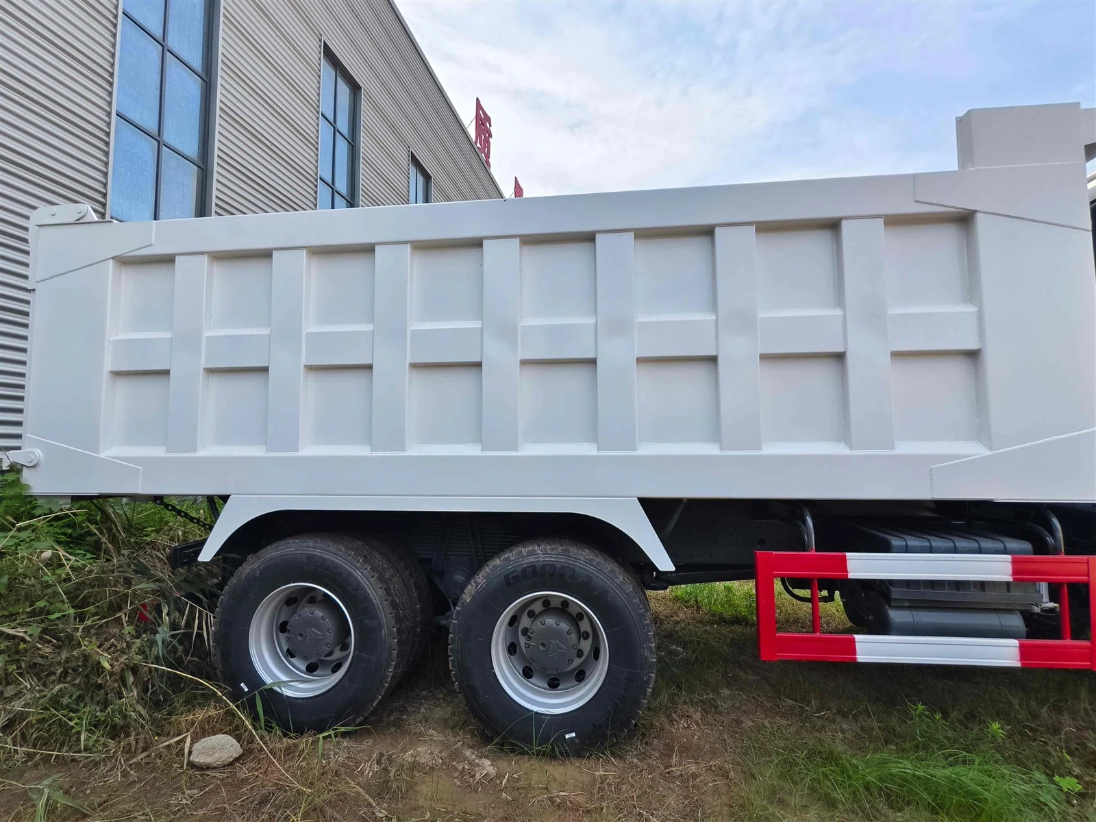White HOWO 6X4 Tipper White Cargo Box Side Profile View White HOWO 6X4 Tipper White Cargo Box Side Profile View